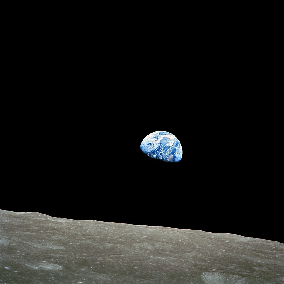 Taken by Apollo 8 crewmember Bill Anders on December 24, 1968, at mission time 075:49:07 [8] (16:40 UTC), while in orbit around the Moon, showing the Earth rising above the lunar horizon. National Aeronautics and Space Administration, Public domain, via Wikimedia Commons